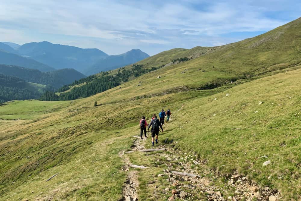 Eine Gruppe von Menschen wandert auf einem Wanderweg in den österreichischen Bergen.