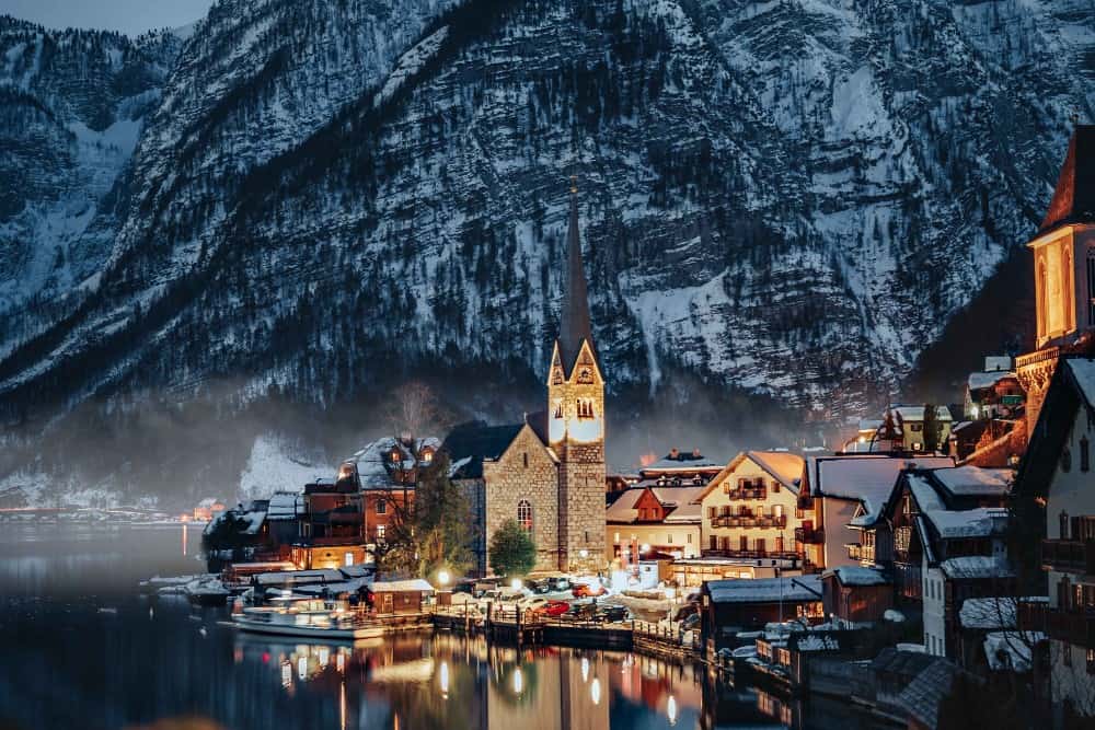Während eines magischen Österreich-Urlaubs erstrahlt eine kleine Stadt in den Bergen nachts im Lichterglanz.