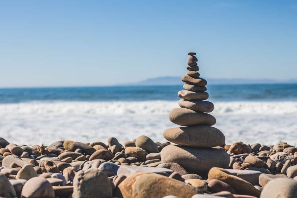 Ein Steinhaufen am Strand mit dem Meer im Hintergrund, perfekt für einen Österreich-Urlaub oder einen Familienurlaub mit Kindern.