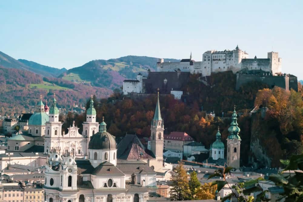 Eine Stadt mit einer Burg auf einem Hügel, perfekt für einen Österreich-Urlaub.