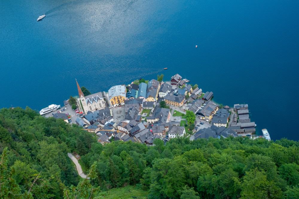 Eine Luftaufnahme von Hallstatt, einem malerischen Dorf an einem See während der Reisezeit.