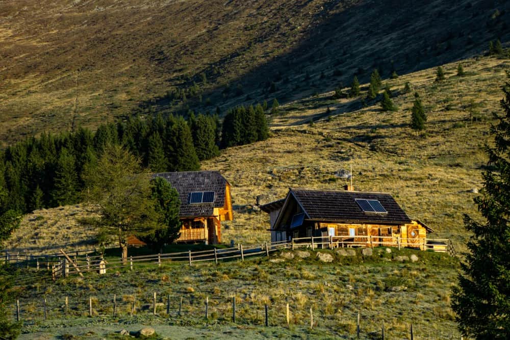 Eine kleine Hütte in den österreichischen Bergen mit Solarpanelen auf dem Dach kann gemietet werden.
