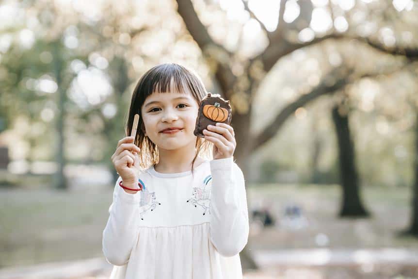 Ein kleines Mädchen hält einen Keks in einem Park.